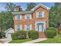 Charming two-story brick home with manicured landscaping and a detached garage at 3196 Henderson Walk, Atlanta, GA 30340