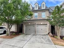 Charming brick townhome with a two-car garage and well-maintained landscaping at 5535 Bright Cross Way, Suwanee, GA 30024