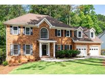 Charming brick home with two-car garage, manicured lawn, and inviting front entrance at 1096 Polo Club Nw Dr, Marietta, GA 30064