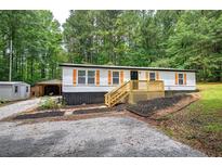 Charming single-story home with a welcoming porch and lush green surroundings at 12208 Buchanan Hwy, Temple, GA 30179