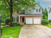 Charming two-story home with brick and gray siding, well-manicured lawn, and a two-car garage at 740 Orchard Ct, Atlanta, GA 30328