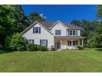 Charming two-story home featuring a manicured lawn, inviting porch, and classic architectural details at 1615 Burnt Oak Way, Dacula, GA 30019