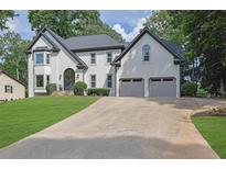 Beautiful two-story home with a well-manicured lawn, two-car garage, and a classic white stucco facade at 525 Old Path Xing, Roswell, GA 30075