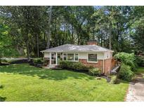 Charming single-story home with a brick facade, manicured lawn, and mature trees at 839 Cardova Ne Dr, Atlanta, GA 30324