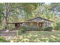 Cozy stone cottage-style home with a covered parking area nestled among mature trees at 270 Bromack Se Dr, Atlanta, GA 30315