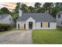 Charming single-story home with a well-manicured lawn, black shutters, and a classic gray front door at 3530 Boulder Cir, Ellenwood, GA 30294