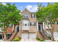 Charming brick townhome with two-car garage and landscaped front yard at 2988 Rivergreen Se Ln, Atlanta, GA 30339