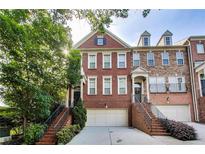 Charming brick townhome featuring a two-car garage and landscaped front yard at 3351 Cumberland Club Dr # 17, Atlanta, GA 30339