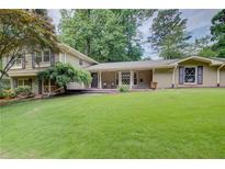 Expansive front yard and charming home exterior with mature trees and traditional architectural details at 4140 Candler Lake West Ne, Atlanta, GA 30319