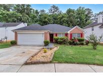 Charming single-story home with brick facade, well-manicured lawn, and attached two-car garage at 4969 Truitt Ln, Decatur, GA 30035