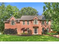 Charming brick home with lush lawn and landscaping at 100 Parkerwood Way, Alpharetta, GA 30022