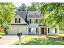 Charming two-story home featuring an attached two-car garage, lush landscaping, and inviting front porch at 40 Queensland Ln, Covington, GA 30016