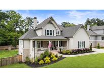 Charming two-story home with a welcoming front porch and beautifully landscaped yard at 4395 Capstone Court, Roswell, GA 30075