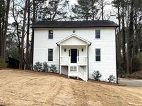 Charming two-story home with white siding, black door, and inviting front porch at 3663 Heatherwood Ne Dr, Marietta, GA 30066