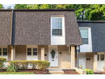 Charming townhome with brick facade, complemented by a well-manicured lawn and tasteful landscaping at 5170 Chemin De Vie Ne, Sandy Springs, GA 30342