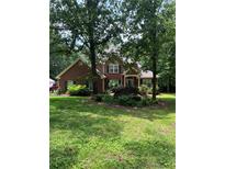 Two-story brick home with lush green lawn and mature trees, offering shade and curb appeal at 50 Ranger Se Rd, Cartersville, GA 30121