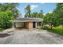 Charming single-story brick home with a covered carport and lush, mature landscaping creating curb appeal at 2880 Shallowford Rd, Chamblee, GA 30341
