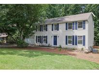Two-story home with white siding, blue shutters, well-manicured lawn and mature trees at 9470 Hillside Dr, Roswell, GA 30076