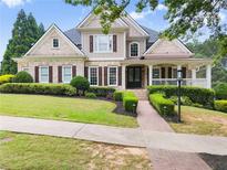 Charming two-story home with manicured lawn, brick walkway, and inviting front porch at 4526 Meadow Club Dr, Suwanee, GA 30024