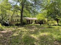 Charming single-story home with brick facade and a lush, treed front yard at 4701 Cleveland Rd, Lithonia, GA 30038