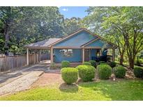 Charming blue home with a welcoming front porch, covered parking, and a well-manicured lawn at 730 Brownwood Se Ave, Atlanta, GA 30316