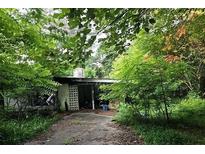 Exterior shot of neglected home with overgrown vegetation and run-down appearance at 2440 Andy Mountain Rd, Villa Rica, GA 30180
