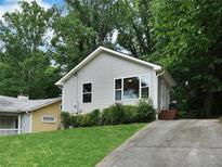 Charming home with light siding, lush landscaping, and a long driveway leading up to the front entrance at 1625 Orlando Sw St, Atlanta, GA 30311