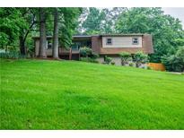 Charming home with a well-manicured lawn, mature trees, and inviting front porch at 407 Doris Dr, Woodstock, GA 30188