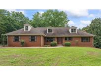 Charming one-story brick home with a well-manicured lawn and mature trees at 103 Seabolt Dr, Locust Grove, GA 30248