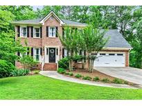 Charming two-story brick home with a well-manicured lawn and mature landscaping at 135 Crimson Rdg, Tyrone, GA 30290