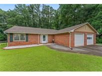 Charming brick home with a well-manicured lawn and two-car garage, perfect for suburban living at 1738 Sherry Ln, Jonesboro, GA 30236