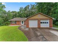 Charming single story brick home with a two car garage and mature shade trees at 1738 Sherry Ln, Jonesboro, GA 30236