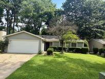 Charming single-story home with a well-manicured front lawn and mature trees at 10630 Worthington Hills Mnr, Roswell, GA 30076