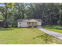 Charming home featuring a freshly landscaped yard, long driveway, and inviting front porch at 2128 Kimberly Rd, Atlanta, GA 30331