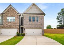 Charming townhome featuring a two-car garage and manicured lawn at 2629 Irwell Way, Lawrenceville, GA 30044