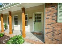 Inviting front porch with wooden pillars and a charming green front door at 5254 Corinth Dr, Stone Mountain, GA 30087