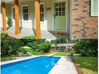 Inviting front porch with rustic wood columns and charming green door at 5254 Corinth Dr, Stone Mountain, GA 30087