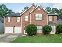 Charming two-story brick home with well-manicured lawn and two-car garage at 6528 Carriage Ln, Stone Mountain, GA 30087