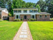 Charming two-story home with a beautifully landscaped yard and inviting stone pathway at 1373 Brawley Ne Cir, Brookhaven, GA 30319