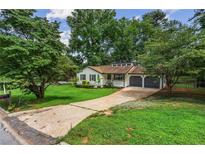 Charming single-story home with a well-manicured lawn and an attached two-car garage at 3833 Paddington Trail, Rex, GA 30273
