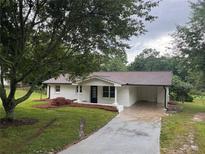 Charming brick home with a covered front porch and driveway showcasing curb appeal at 4706 Piney Grove Rd, Cumming, GA 30040