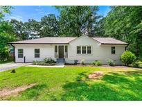 Charming single-story home with a well-manicured lawn and lush landscaping at 381 Warner Se St, Marietta, GA 30060