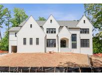 Striking white brick home featuring symmetrical gables and black-framed windows at 3118 Lanier Ne Dr, Brookhaven, GA 30319