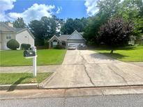 Traditional home with green lawn, long driveway, and mailbox at the curb at 148 Parkside Dr, Stockbridge, GA 30281