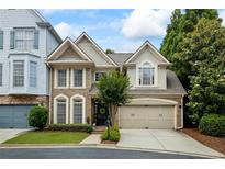 Charming brick home featuring a two-car garage, manicured lawn, and beautiful landscaping at 200 Mystic Ct, Atlanta, GA 30342
