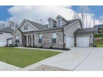 Charming single-Gathering home featuring a brick facade, attached garage, and well-maintained landscaping at 449 Carmichael Cir, Canton, GA 30115