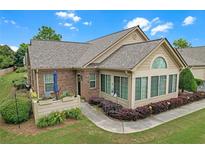 Inviting home exterior with manicured landscaping, charming brick accents, and a cozy outdoor seating area at 1402 Silver Summit Se Dr, Conyers, GA 30094