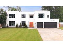 Stunning modern home featuring an attached two-car garage, manicured lawn and eye-catching orange front door at 2220 Meadowvale Ne Dr, Atlanta, GA 30345