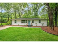 Charming home featuring a freshly manicured lawn and a striking turquoise front door at 3160 Ann Se Rd, Smyrna, GA 30080