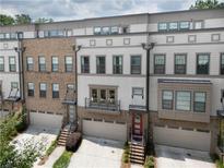 Charming townhome exterior featuring brick and siding, with a private balcony, and attached garage at 1066 Brandsford Nw St, Atlanta, GA 30318